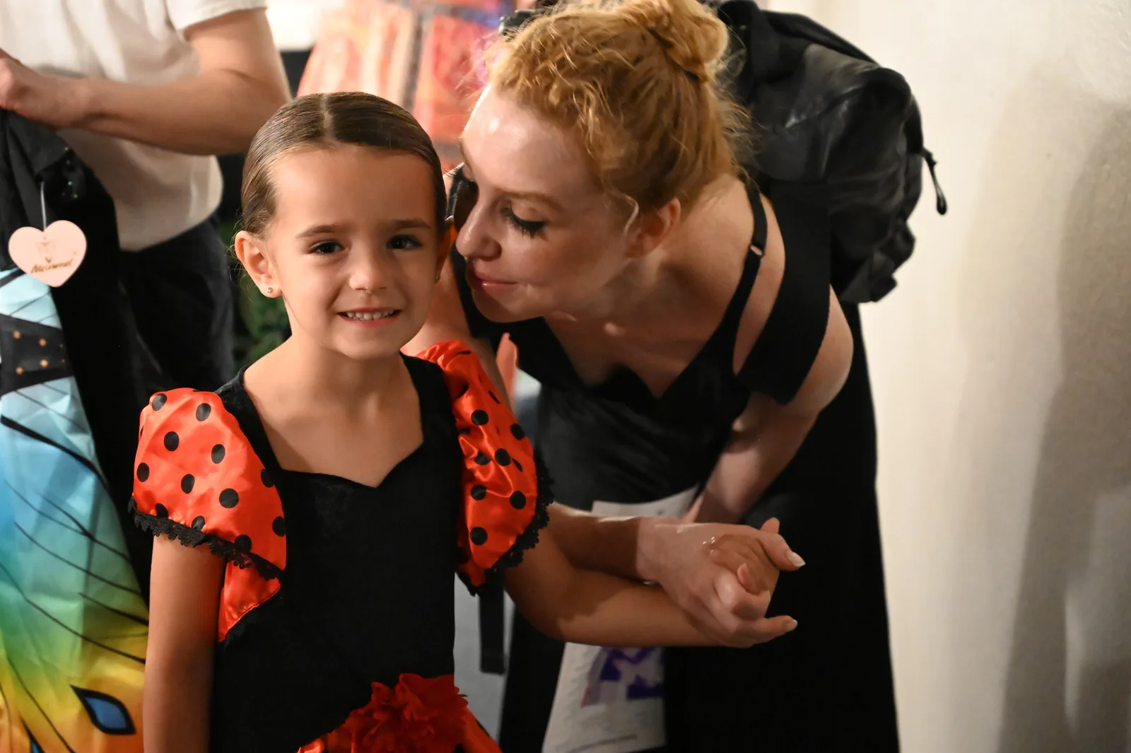 Teacher hugging a young performer backstage before the show