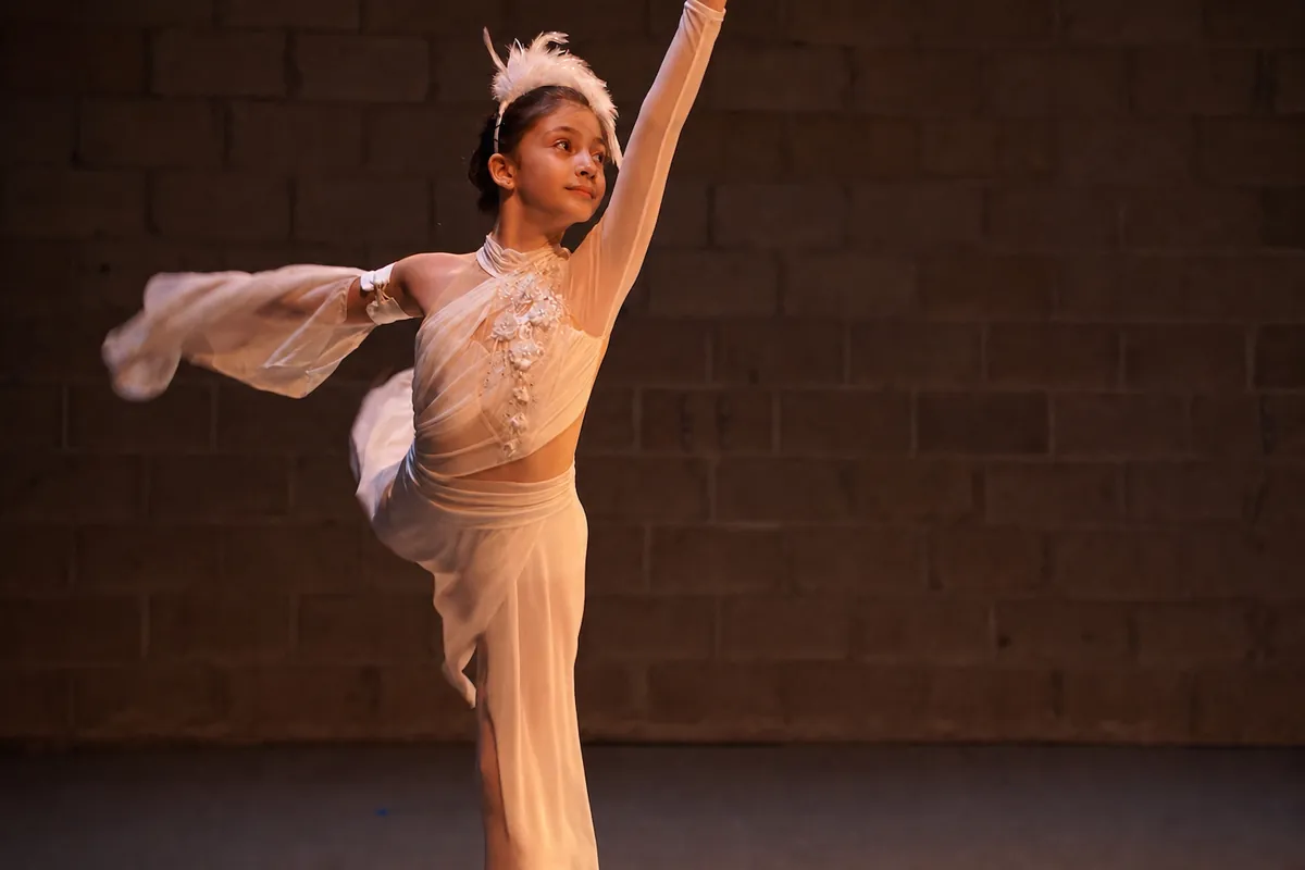 A student holding an arabesque with a trailing veil in a solo passage