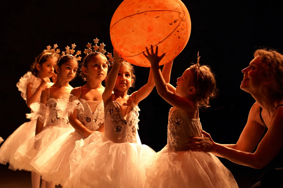 A young student reaches up to touch the little prince's planet during the June 2026 performance